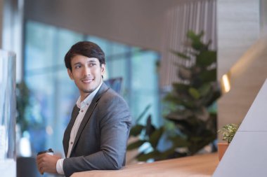 Tatilde ofiste kahve içen iş adamının portresi..