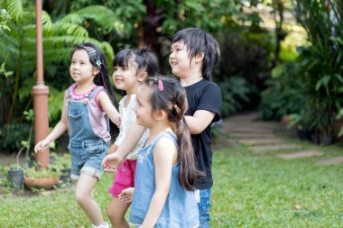 Çocuklar arkadaşlarıyla dışarıda oynuyorlar. Küçük çocuklar doğa parkında oynuyorlar..