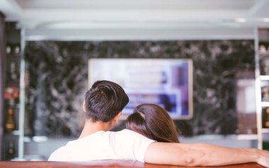 Oturma odasında televizyon izleyen çiftin dikiz görüntüsü