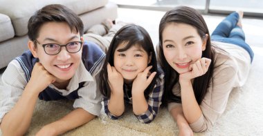 Mutlu Asyalı aile oturma odasındaki kanepede birlikte vakit geçiriyor. aile ve ev kavramı