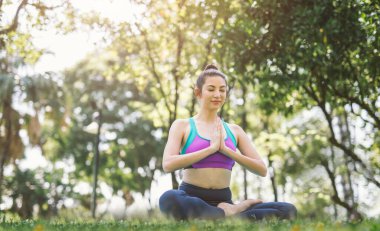 Parktaki yoga sağlıklı bir egzersiz. Avuç içlerinizi birleştirin ve selam verin.