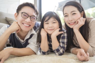 Mutlu Asyalı aile oturma odasındaki kanepede birlikte vakit geçiriyor. aile ve ev kavramı