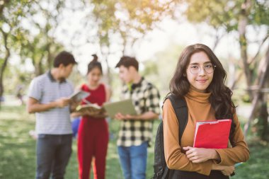 Eğitim, kampüs, arkadaşlık ve insanlar konsepti - okul klasörleri olan bir grup mutlu Asyalı genç öğrenci