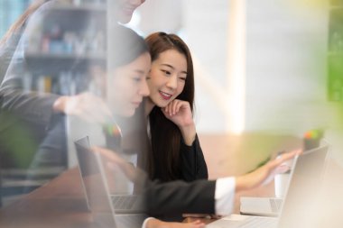 İşadamları ofiste dizüstü bilgisayarla çalışıyorlar. Çalışma ve proje hakkındaki fikirleri ortaklarla paylaşan bir grup iş adamı