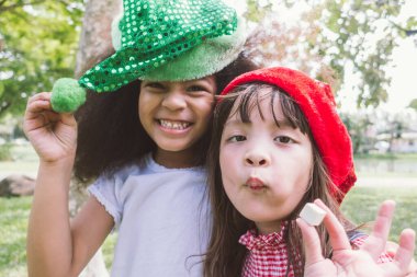 Gülümseyen iki küçük kız parti şapkası takıyor.