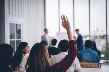 Seminer sınıfındaki kadınlar konferans seminer salonunda konuşmacı ile aynı fikirde olmak için ellerini ve kollarını kaldırdılar. 