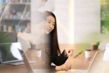 İşadamları ofiste dizüstü bilgisayarla çalışıyorlar. Çalışma ve proje hakkındaki fikirleri ortaklarla paylaşan bir grup iş adamı 