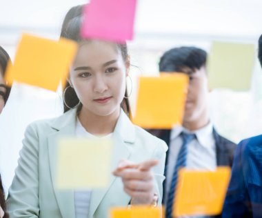 Asyalı iş adamları bunu tartışarak ve planlayarak camın önüne not bırakıyorlar.