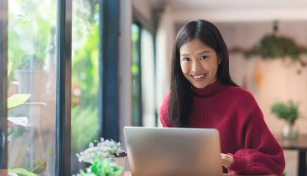 Bir Kafede Dizüstü Bilgisayarla Çalışan Mutlu Bir Asyalı Genç Kız — Stok fotoğraf