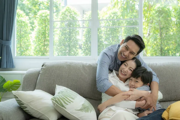 Mutlu Asyalı aile oturma odasındaki kanepede birlikte vakit geçiriyor. aile ve ev kavramı
