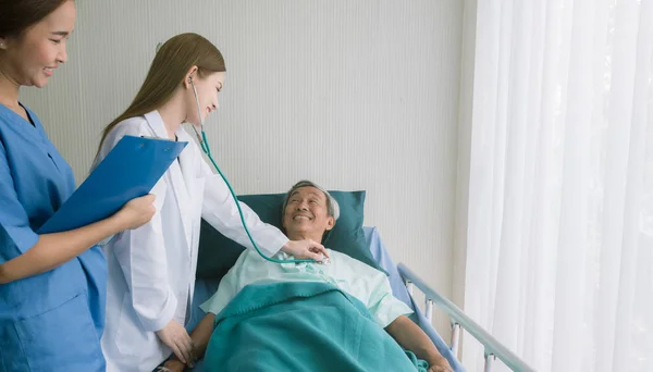 Güzel Asyalı Doktor Hastane Yatağında Kalp Hastalarını Dinliyor — Stok fotoğraf