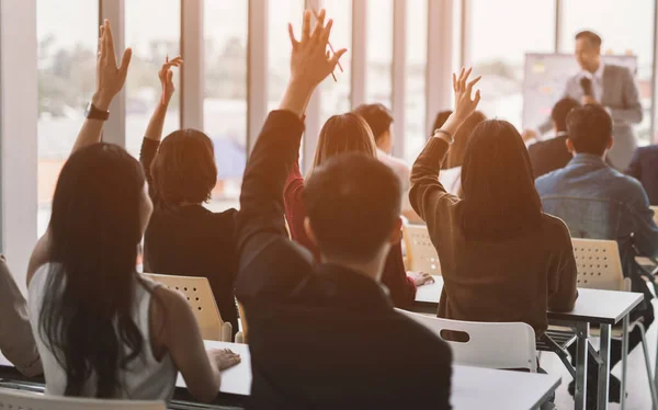 Seminer sınıfındaki büyük bir grubun ellerini ve kollarını kaldırıp konferans seminer salonunda konuşmacı ile aynı fikirde oldular. 