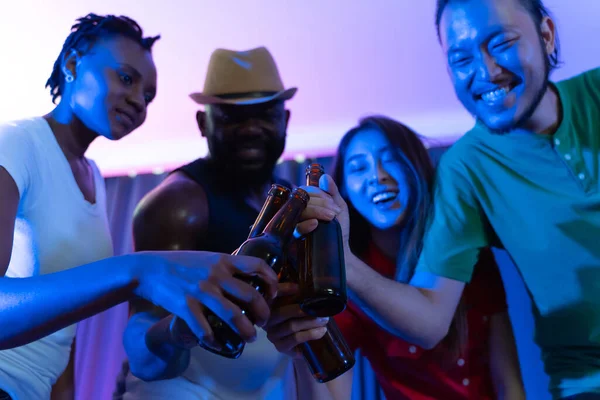 Group of happy friends drinking and toasting beer