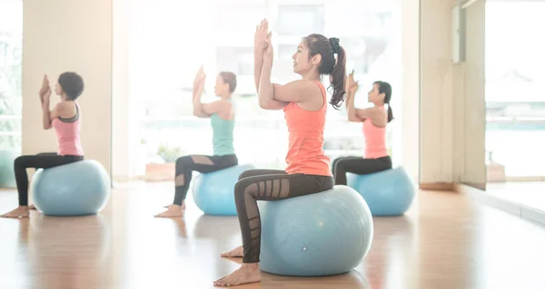 瑜珈和人的概念 亚洲女人在体操中伸展瑜伽球 一组在室内做瑜伽的女子 — 图库照片