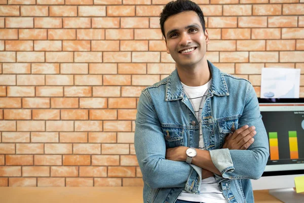 Portrait young Asian Indian business man in modern office looking at camera