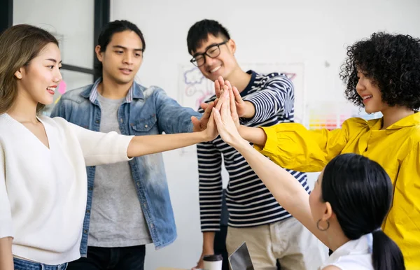 年轻的亚洲创意商业团队给出了一个很高的手势团队合作庆祝派对成功的理念 — 图库照片