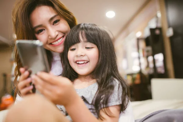 肖像画快乐女儿和妈妈玩智能手机 — 图库照片