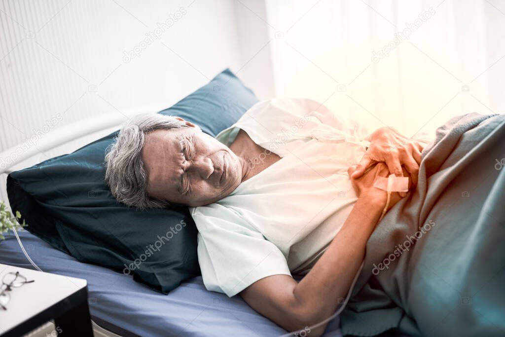 Mature man suffering from stomachache. Senior Patient on the bed and pain stomach at room in the hospital.