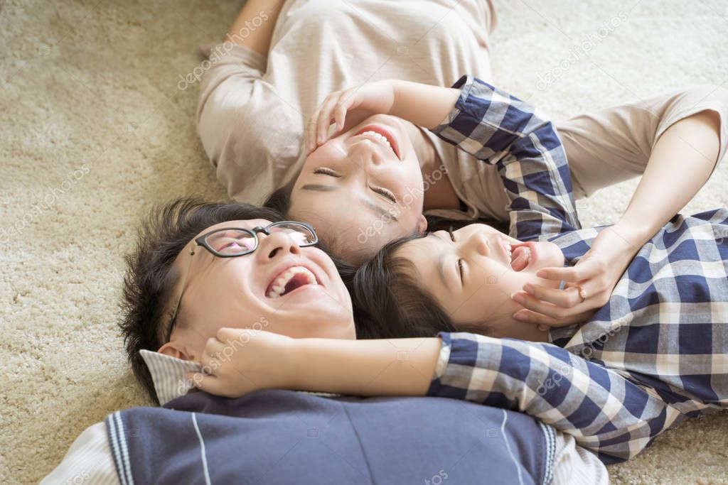Portrait Happy Asian Family laying down and playing in living room
