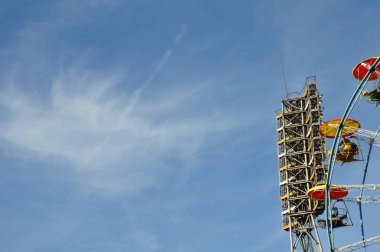 Şehrin dönme dolabının üzerinde bulutlu mavi gökyüzü.