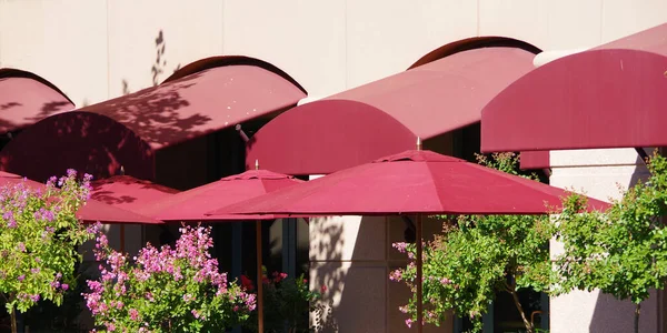 Red umbrellas and awnings over the outside seatings of an urban bistro
