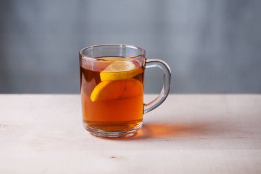 Şeffaf kupa limon ve çay ve çay poşeti. Ahşap yüzey