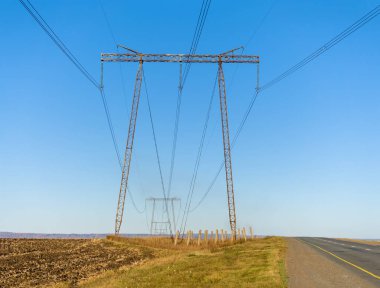 Elektrik teli perspektif olarak destekliyor. Kırsal alan güneşli sonbahar günü