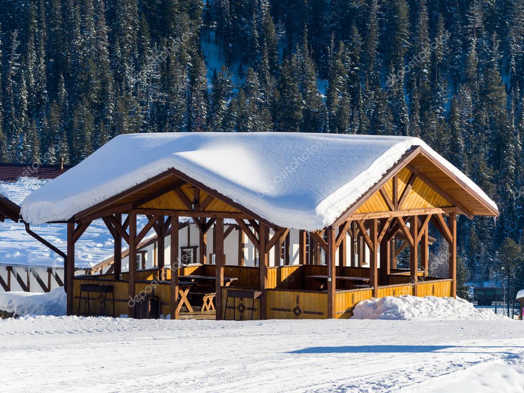 A beautiful alpine-style gazebo in the Gornaya Salanga ski resort. Winter sunny day