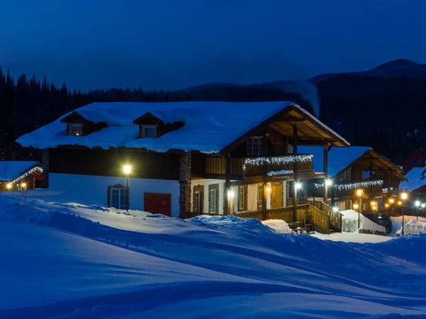 スキーリゾートゴルナヤ サランガ夜 青い夕暮れ 黄色の居心地の良い暖かい光が家の中で点灯して落ちている シベリアの冬 — ストック写真