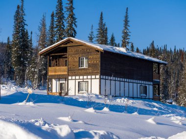 Gornaya Salanga kayak merkezinde Alp tarzı bir otel. Kış güneşli gün, açık mavi gökyüzü