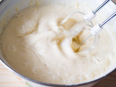 Karıştırıcı Rus krepleri için çabucak un, süt ve yumurta karıştırır. Yakın plan.