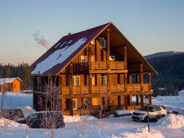 Gornaya Salanga kayak merkezinde Alp tarzı bir otel. Güneş doğuyor. Güzel sabah ışığı