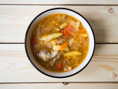 Beyaz tabakta çorba. Rus lahana çorbası, domates ezmesi. Yukarıdan görüntüle