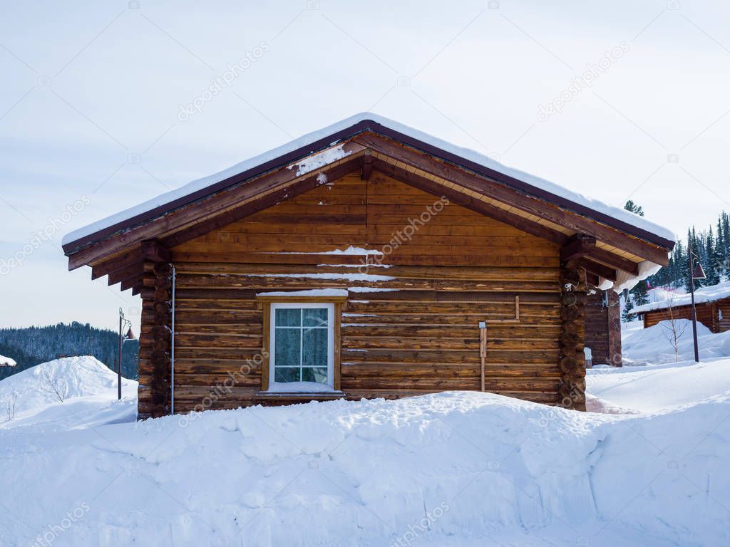 Alpine style wooden chalet. Hotel in the ski resort Gornaya Salanga. Winter day