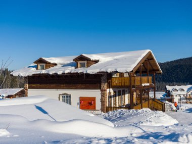 Gornaya Salanga kayak merkezinde Alp tarzı bir otel. Kış güneşli gün, açık mavi gökyüzü