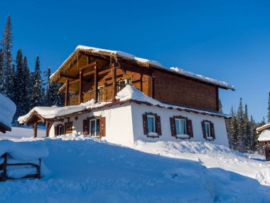 Gornaya Salanga kayak merkezinde Alp tarzı bir otel. Kış güneşli gün, açık mavi gökyüzü