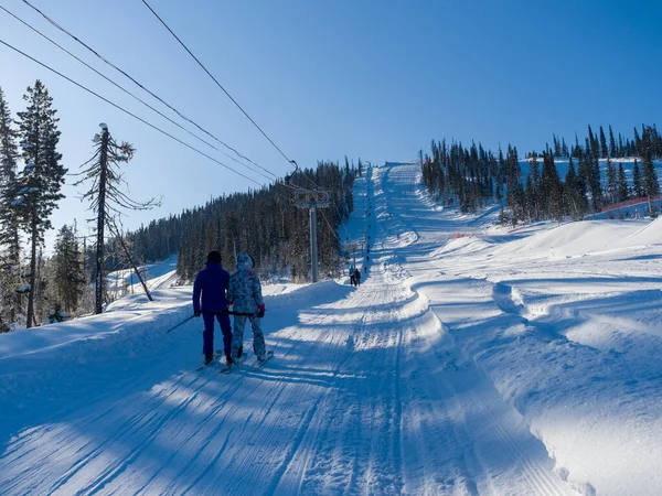 Skiers climb the mountain on a special ski lift. Winter sunny day at the resort