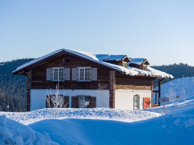 Gornaya Salanga kayak merkezinde Alp tarzı bir otel. Kış güneşli gün, açık mavi gökyüzü