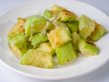 Beyaz bir tabakta kızarmış genç kabak. Yan görünüm