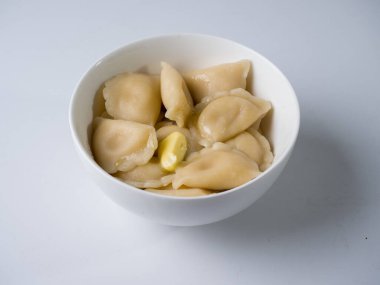 Beyaz bir kasede taze kaynamış hamur tatlısı. Yan görünüm