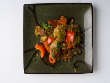 Kare tabakta sıcak kabak ve biber salatası. Üst görünüm