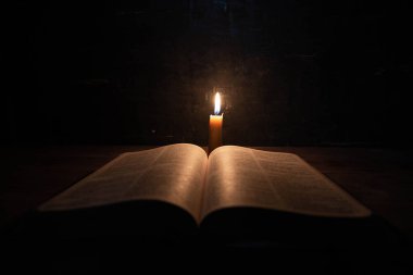 İncil ve mum eski bir meşe ahşap masada. 