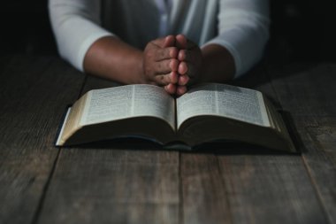 Eller inanç için kilise kavramı bir Kutsal Kitap üzerinde dua katlanmış