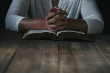 Eller inanç için kilise kavramı bir Kutsal Kitap üzerinde dua katlanmış