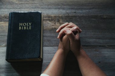 Eller inanç için kilise kavramı bir Kutsal Kitap üzerinde dua katlanmış