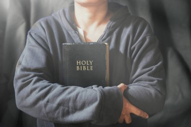 Eller inanç için kilise kavramı bir Kutsal Kitap üzerinde dua katlanmış