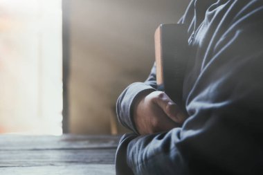 Eller inanç için kilise kavramı bir Kutsal Kitap üzerinde dua katlanmış