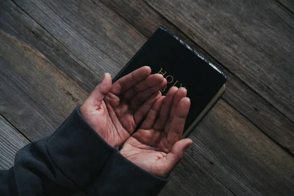 Mani giunte in preghiera su una Sacra Bibbia nel concetto di chiesa per la fede — Foto Stock