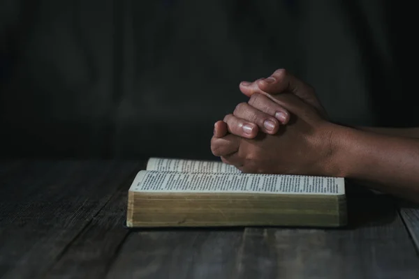 Mãos dobradas em oração em uma Bíblia Sagrada no conceito da igreja para a fé — Fotografia de Stock