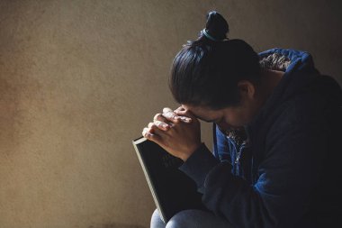 Eller inanç için kilise kavramı bir Kutsal Kitap üzerinde dua katlanmış